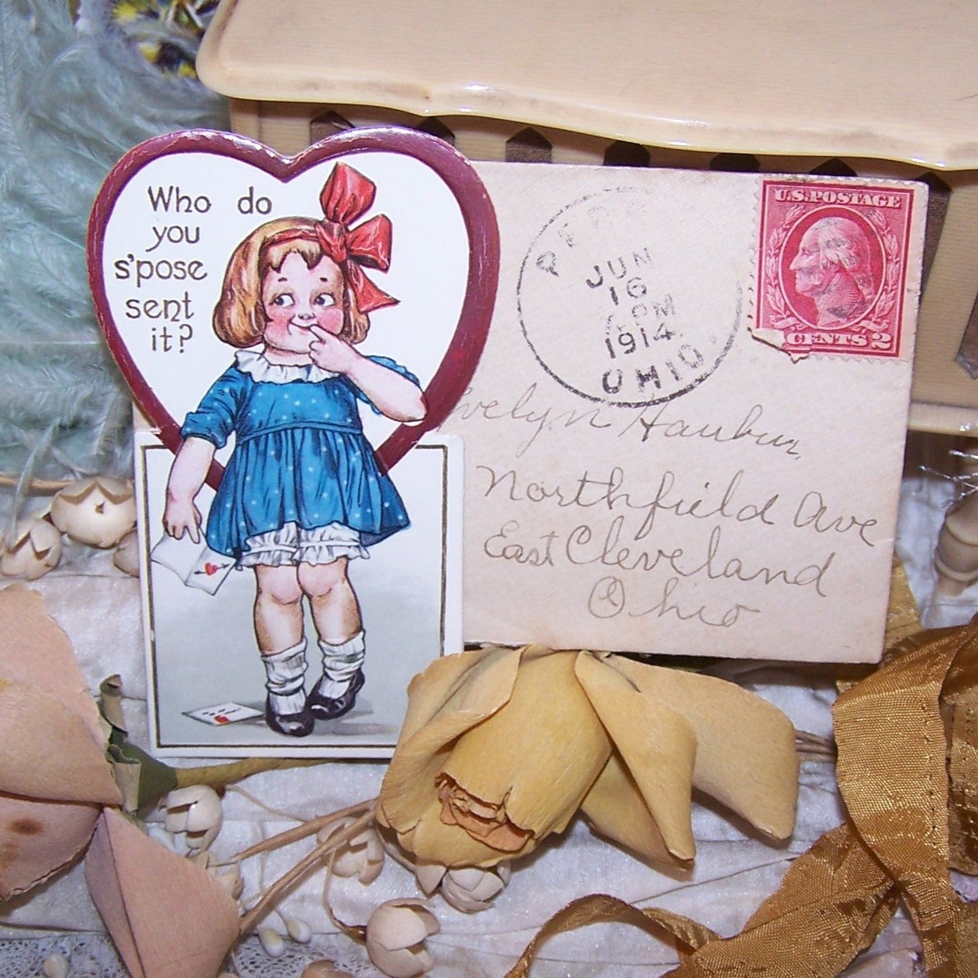 A C.1914 Valentine's Day Card with original mailing envelope. The card depicts a little girl holding a Valentine "Who do you s'pose sent it?". Used condition.
