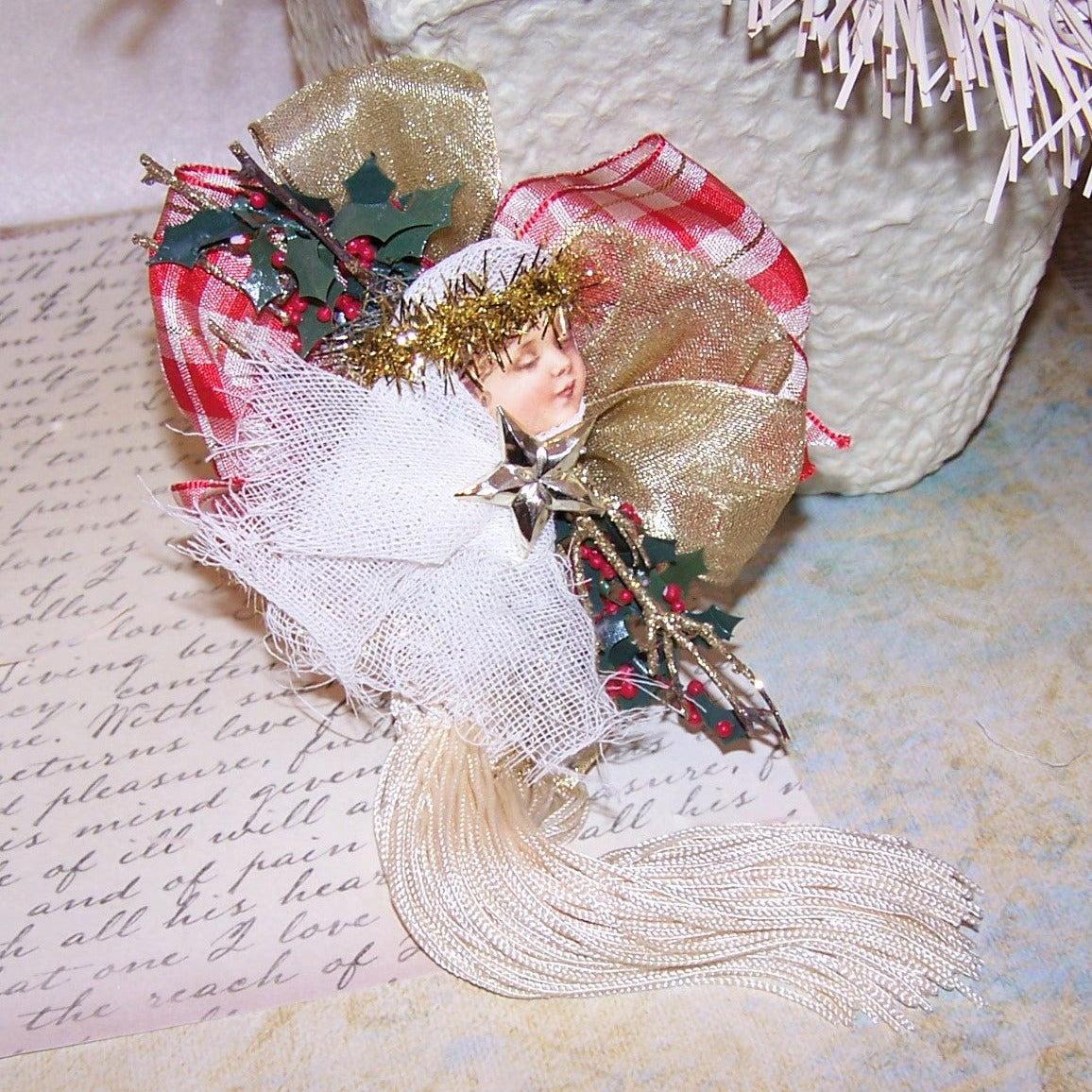 Christmas Angel ornament of Mixed Materials in colors of red plaid, green, gold & cream. Backed with a wood oval which can be personalized by the new owner