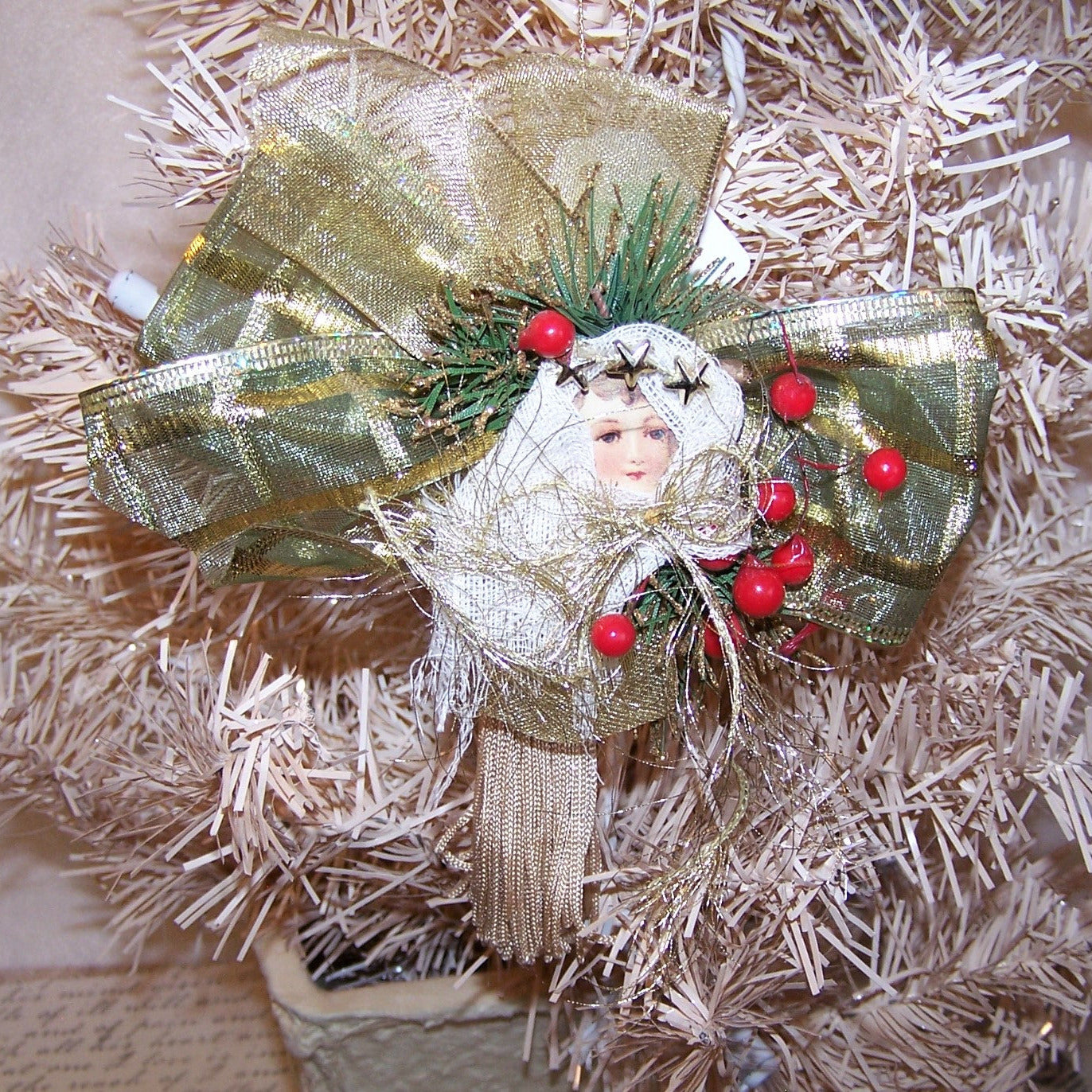 Christmas Angel ornament of Mixed Materials in colors of olive green, red, gold & cream. Backed with a wood heart which can be personalized by the new owner.