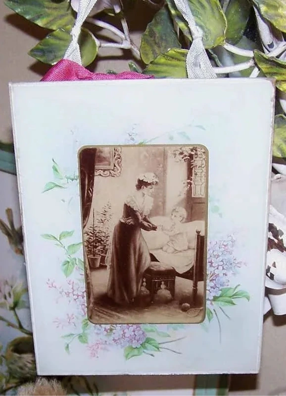 Antique sepia print under glass depicting a mother and child in the nursery. Border image of hyacinths that may be the artwork of Catherine Klein (C. Klein).