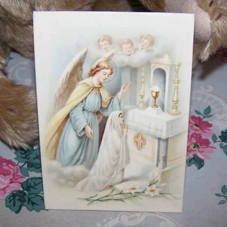 From France, an Art Deco celluloid icon depicting a young girl at her First Communion. Green back with an easel; there is also a ring to hang from a wall.
