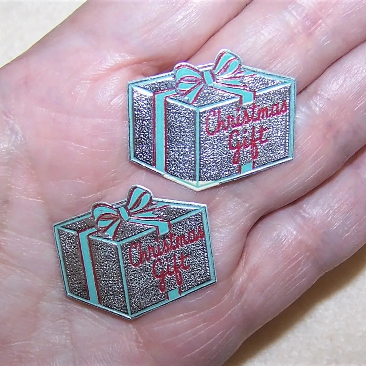 10 silver foil gummed Christmas package stickers. Designed as a Christmas gift, the ribbons are red & green while the sentiment to the top is 'Christmas Gift.'