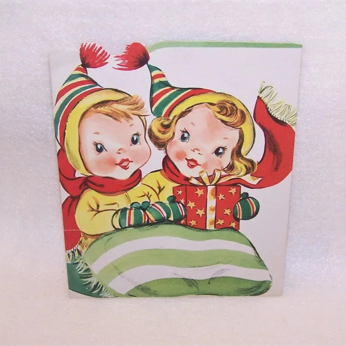 A 1950s Christmas greeting card featuring children in a sleigh. The card is flat, but opens to a 3D self-standing decoration.