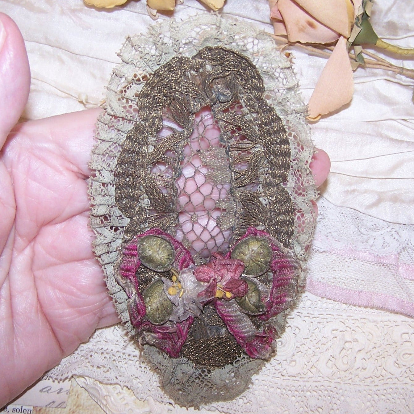 Art Deco French ribbonwork piece from the top of a ladies brush. Gilt metallic lace, blue/grey cotton lace and French Ribbonwork florals. 5" x 2-3/4".