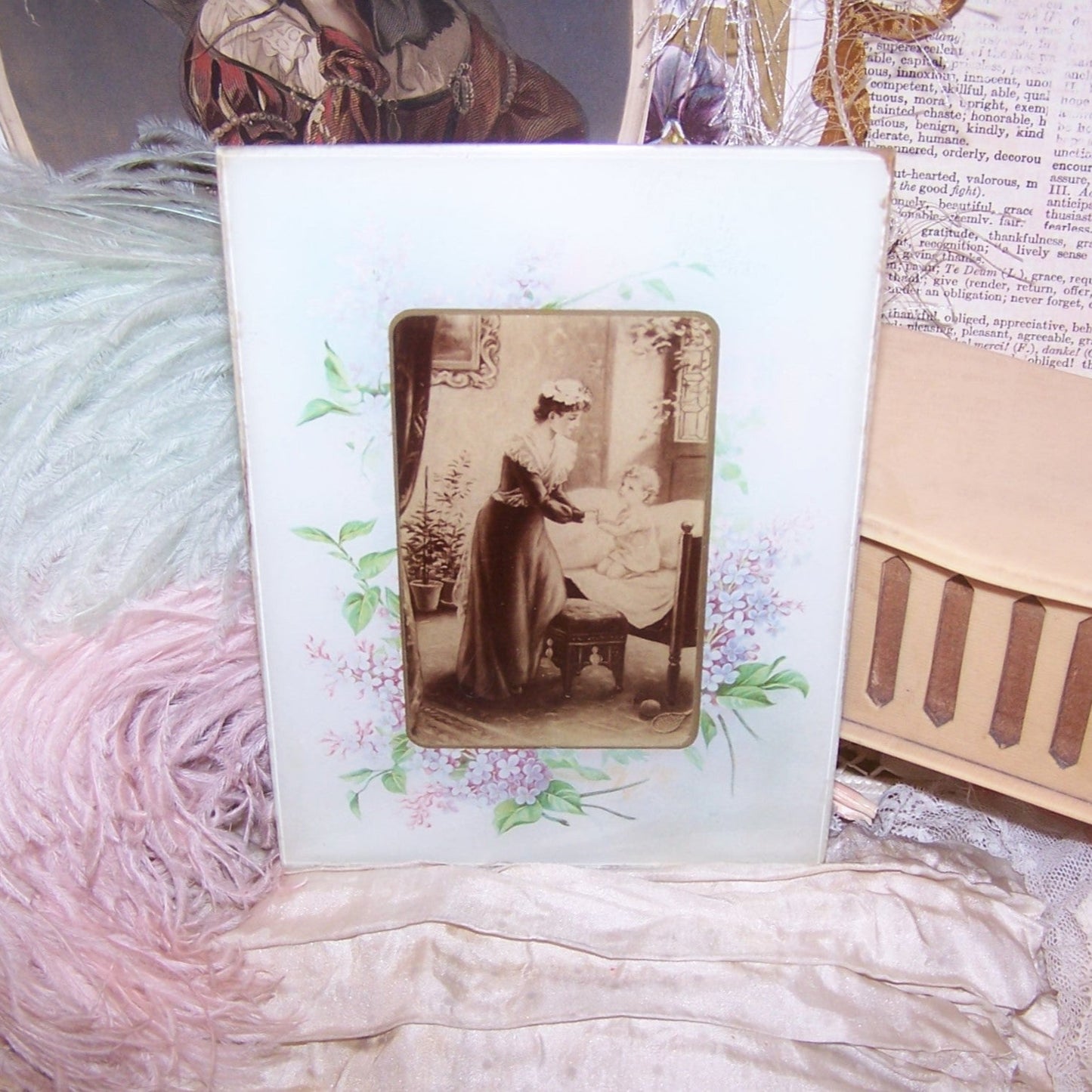 Antique sepia print under glass depicting a mother and child in the nursery. Border image of hyacinths that may be the artwork of Catherine Klein (C. Klein).