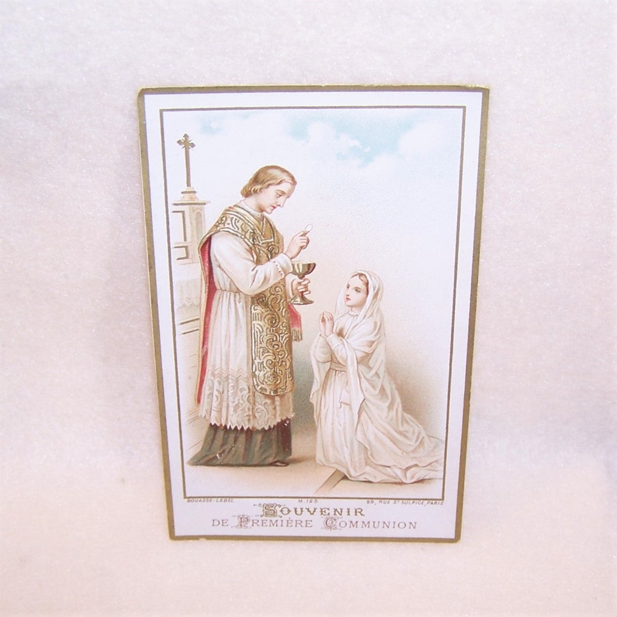 Souvenir de Premiere Communion printed by the French firm of Bouasse-Lebel. The card features a color image of a young girl taking communion. 2-3/4" x 4-3/8".