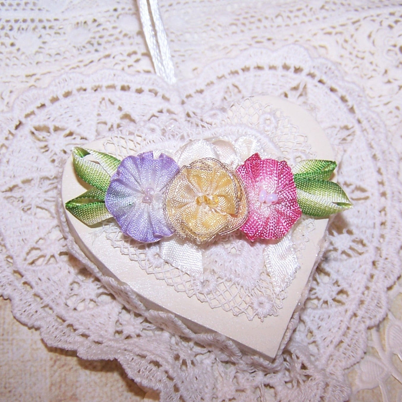 Art Deco French ombre ribbonwork floral spray in colors of yellow, pink and lavender; the centers hold glass beads. End leaves are lime green. 2-1/4" x 5/8".