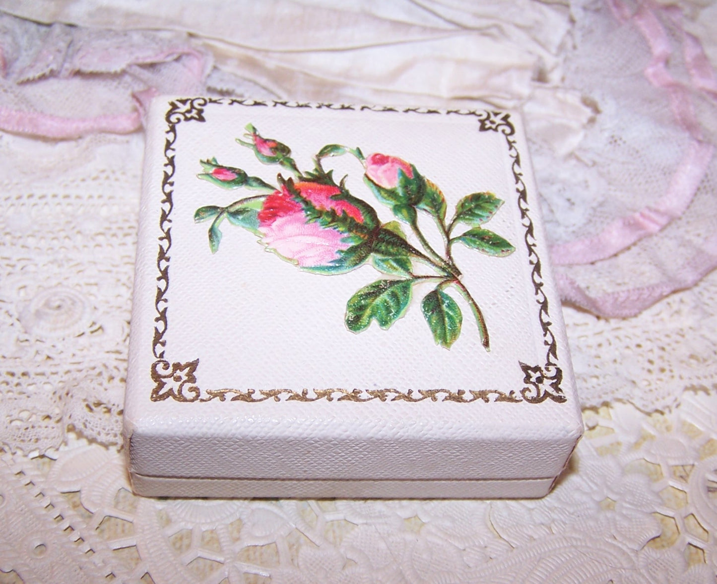 2-3/8" square Jaccards, St Louis jewelry box of cream paper, silk and velvet. Simply "pin" your gift to the velvet pad. Pink roses die cut top.
