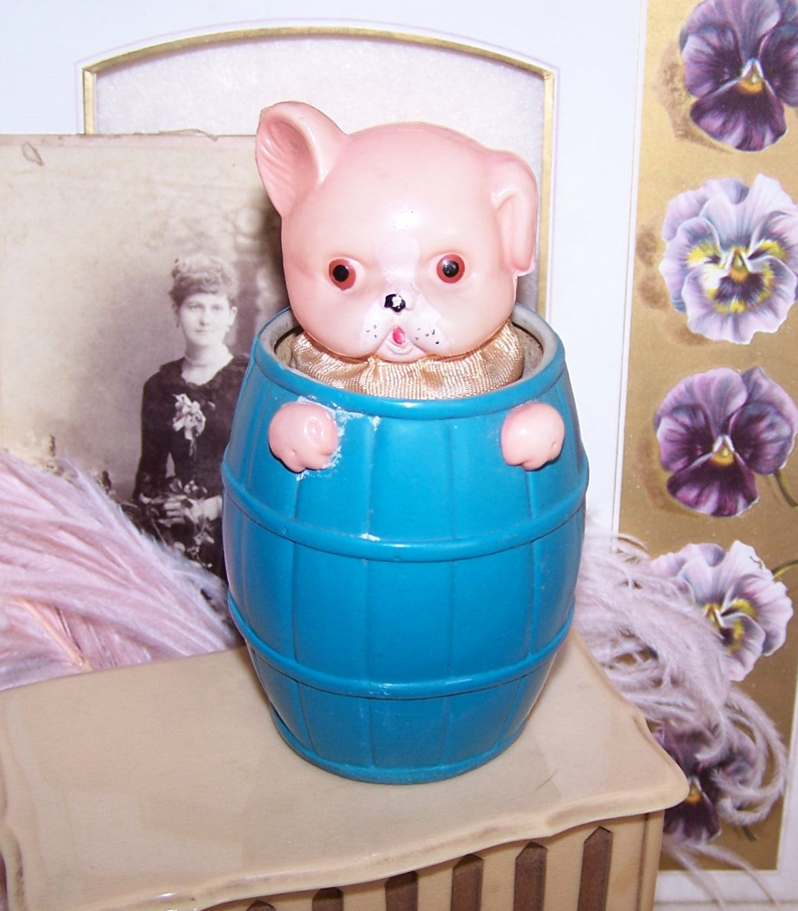 Made in Japan Celluloid display toy - a puppy or a pig stuck in a barrel. You can actually push the head down into the barrel and it pops back up. 4-1/2" high.
