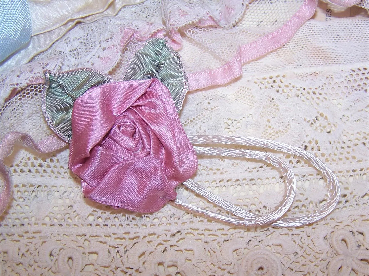 Handsewn Revival French Ribbonwork mauve satin rose / ribbon leaf / cream cord applique or dress embellishment. Size is 1-3/4" wide/high.
