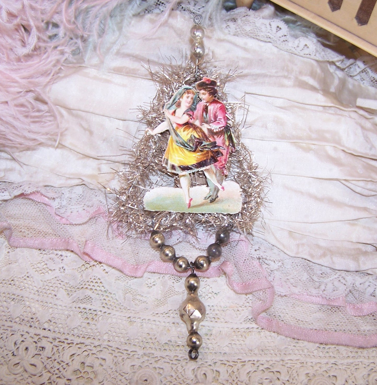Victorian Revival handcrafted silver tinsel and mercury glass Christmas ornament. Antique die cut of a dancing couple. Light but lengthy. One of a Kind