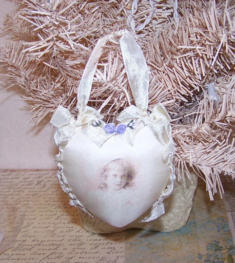 Starting with a Banar Designs pre cut foam form, I covered the heart with cream satin (back) and a silk transfer (front). The young girl printed to the front is my logo image and she has been printed ever so softly onto the silk. Cream rayon ribbon edging. Size is 3-1/2" x 3-1/2". One of a Kind.