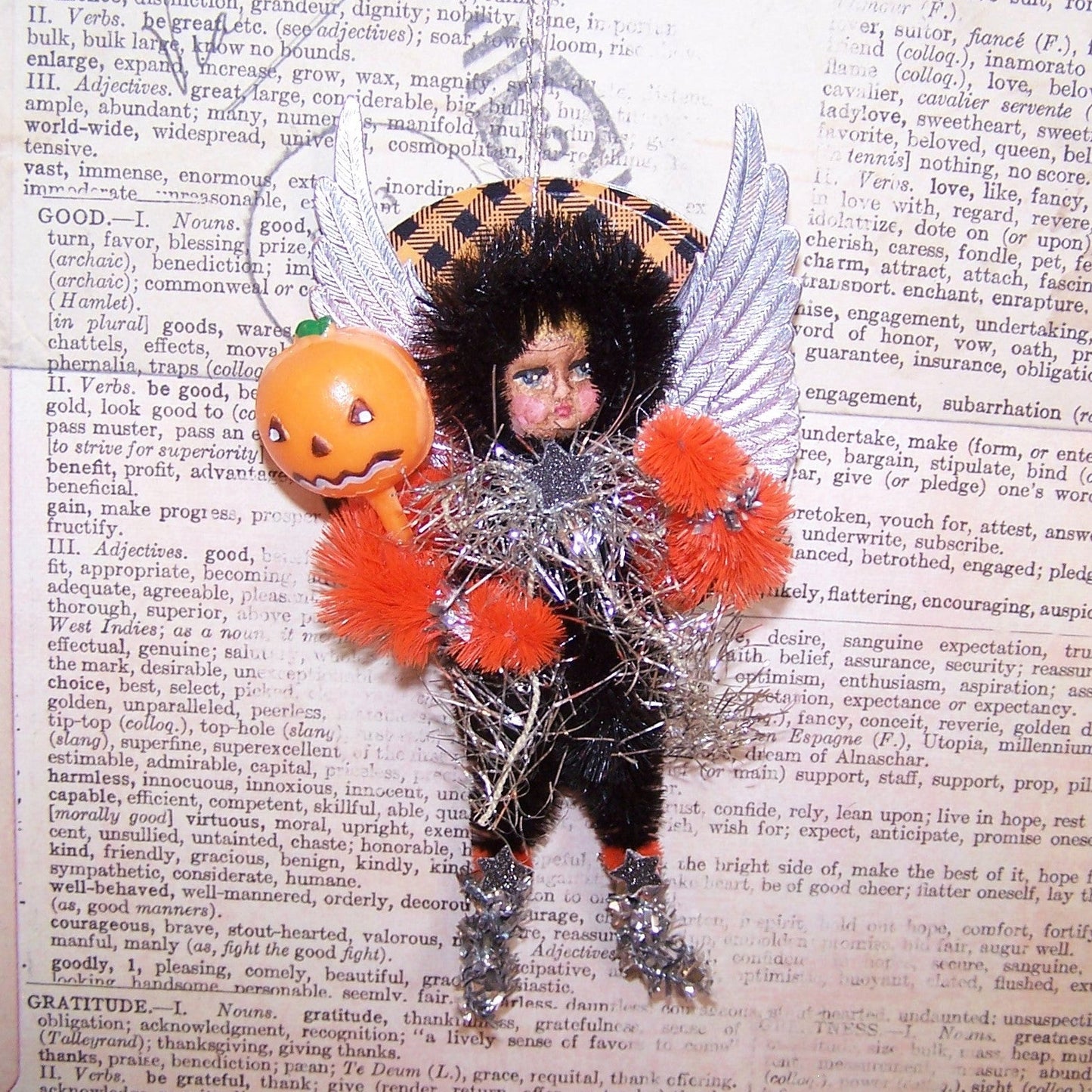 With silver Dresden paper wings, my OOAK little girl Trick or Treater Halloween ornament carries a plastic Jack o Lantern pick. 5" x 2-1/2" approx.