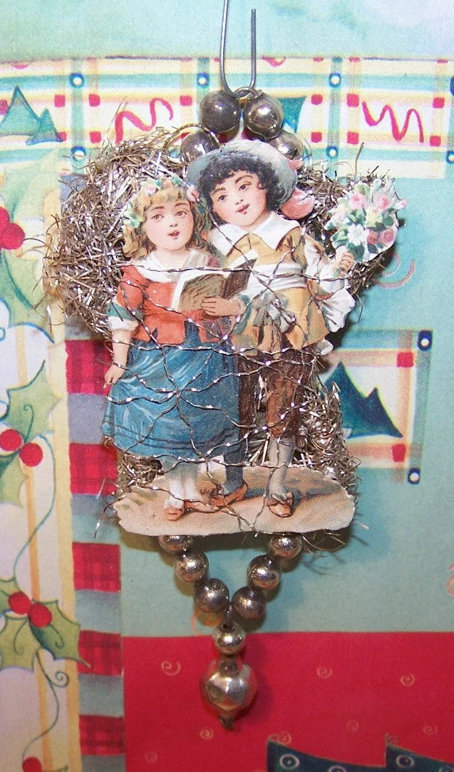Victorian revival handmade christmas holiday ornament. With silver tinsel wrapped around a wire armiture, the piece is embellished with made in Japan silver colored mercury glass beads. The design of the decoration is of a young couple (children) singing a song; their dress suggests the Oliver Cromwell period in England. height is about 4-3/4". Very fine condition - very sturdy.
