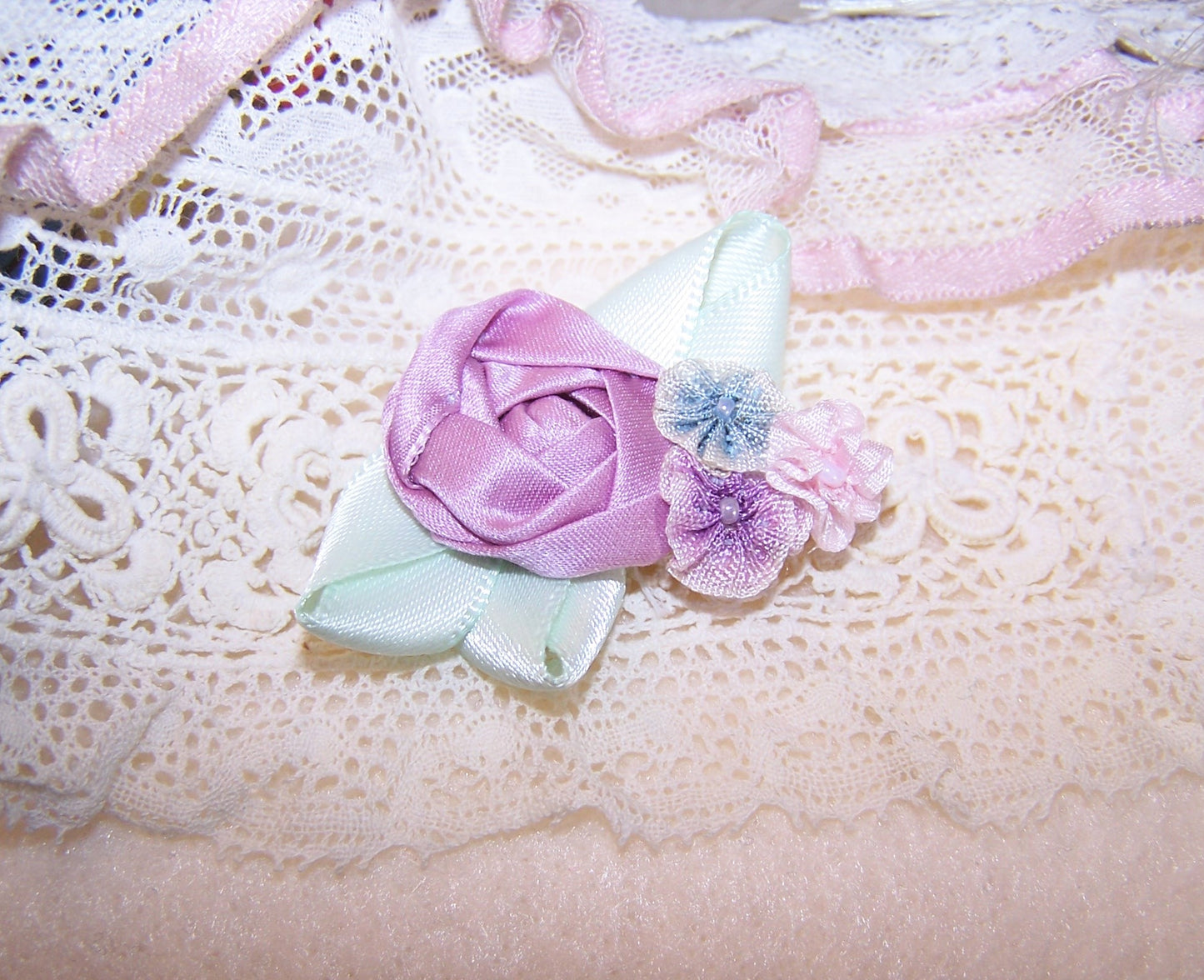 French Revival ribbonwork spray featuring 4 florals - a center mauve cabbage rose surrounded by pink, blue & lavender ombre accents.  Handsewn.