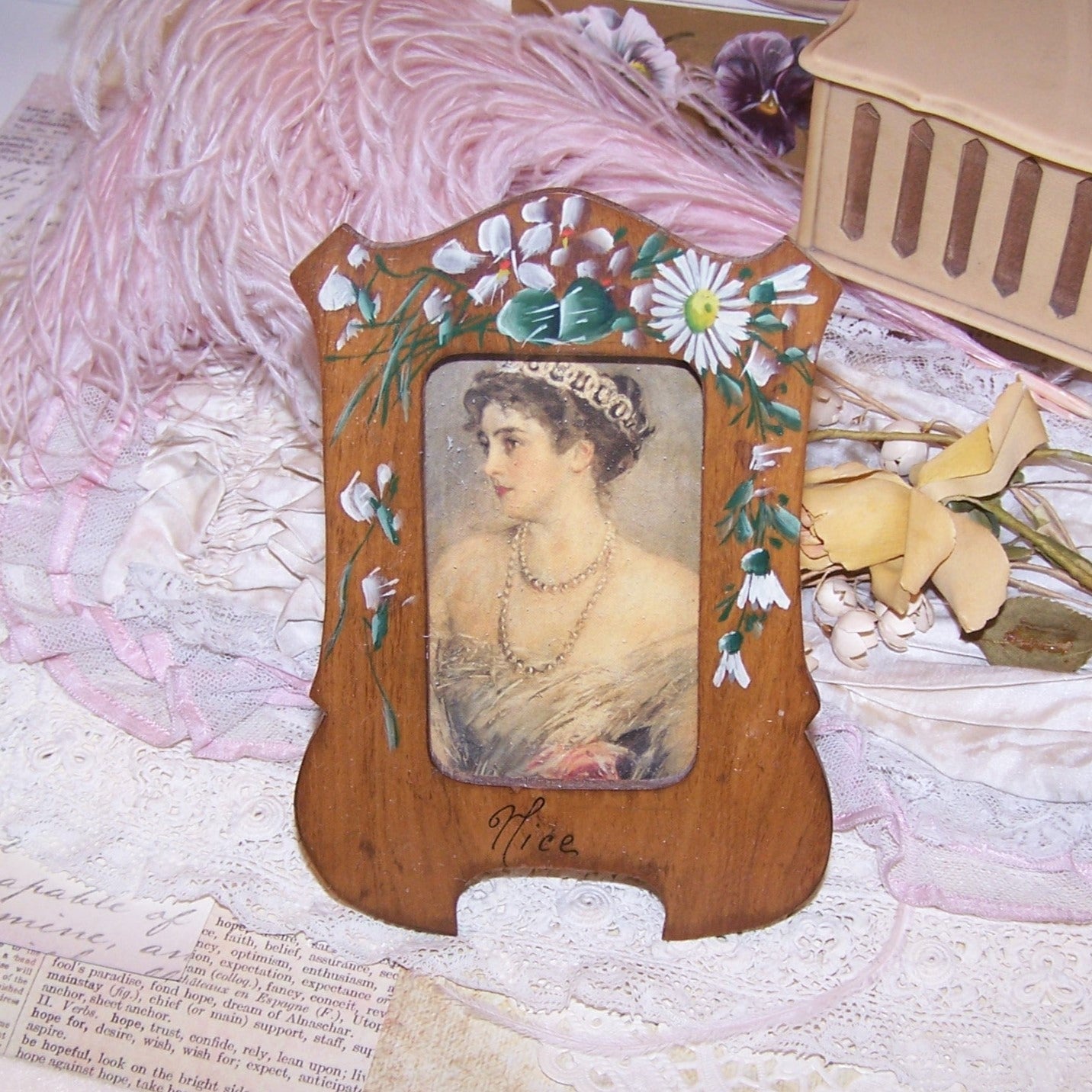 Souvenir of Nice, France here's a tabletop Olive Wood picture frame that has been hand painted with violets and daisies. Intact original glass.   