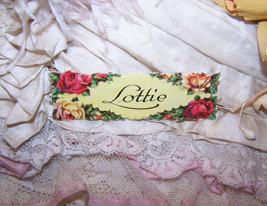 Antique Victorian Die Cut - a Name Tag for LOTTIE. Set at the center of a 2-1/2" x 9/16" rectangle, the scrap piece has never been used.