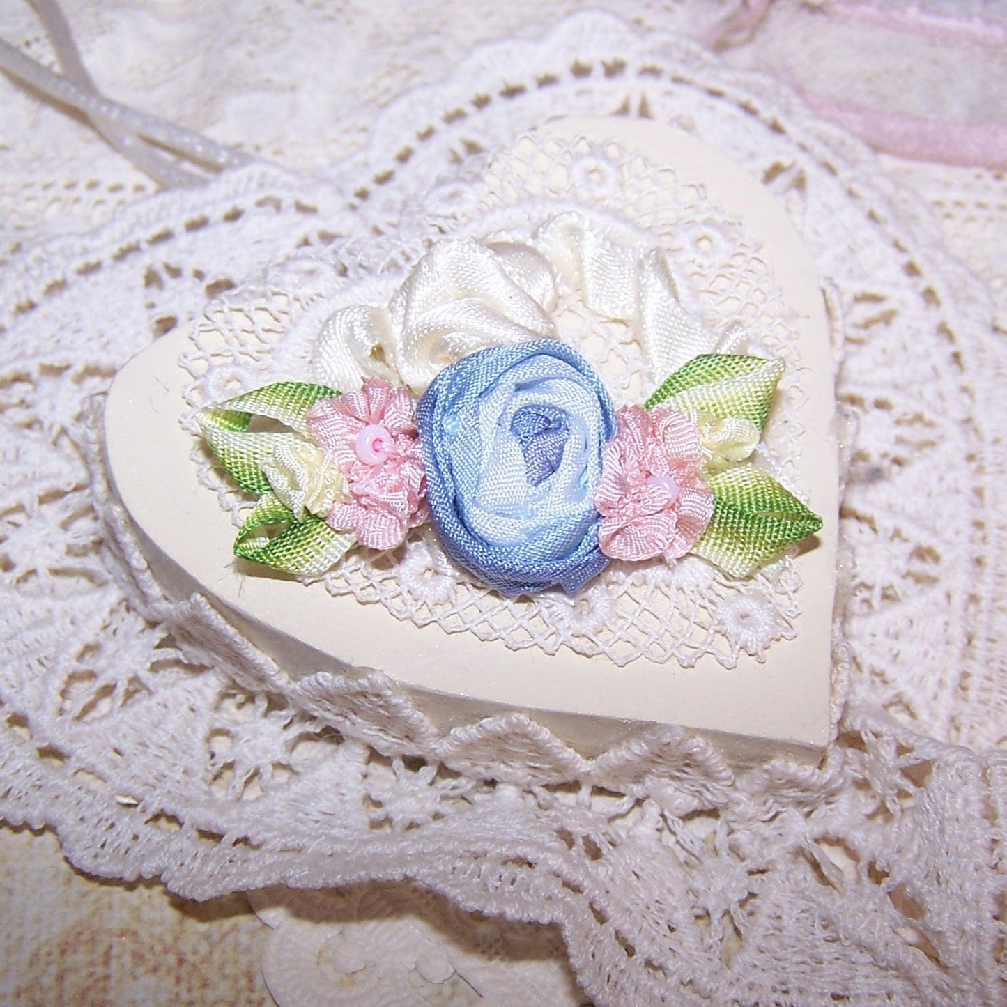 French Revival ribbonwork spray of 3 florals - a blue silk cabbage rose shouldered by a pair of pink silk florettes, the centers set with glass beads. 
