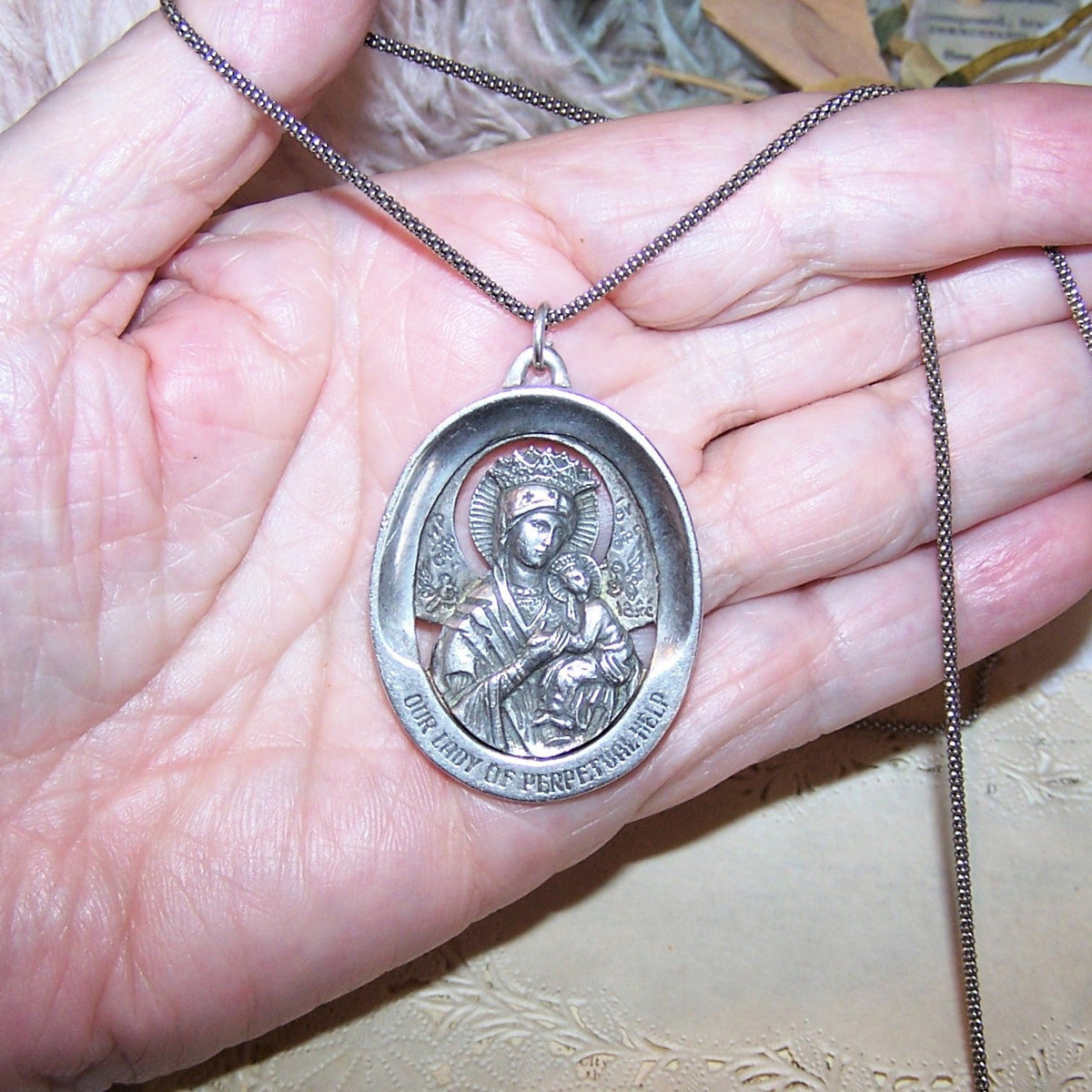 Made in USA by WESTON, a 1960s Sterling Silver religious oval medal pendant with Our Lady of Perpetual Help to the top, Sacred Heart of Jesus to the back.