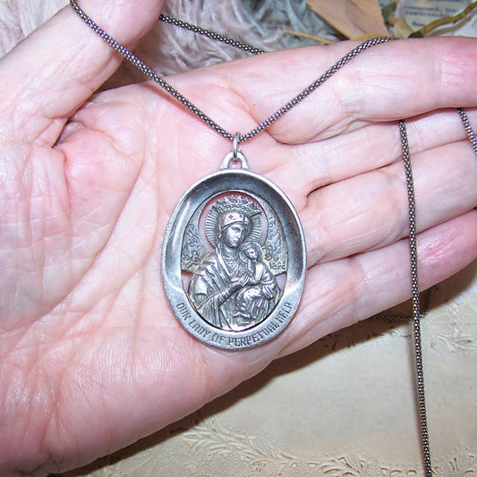 Made in USA by WESTON, a 1960s Sterling Silver religious oval medal pendant with Our Lady of Perpetual Help to the top, Sacred Heart of Jesus to the back.
