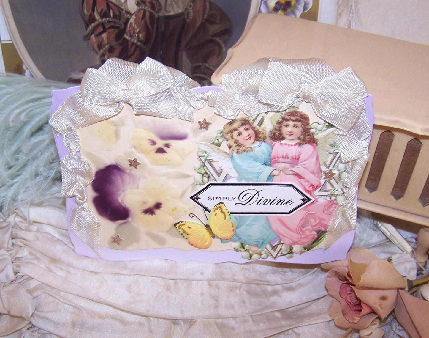 Handcrafted everyday greeting card/ornament of mixed materials.  Two Angels, Pansies and a Butterfly.  Sentiment is SIMPLY DIVINE.  Rayon Ribbon Hanger.