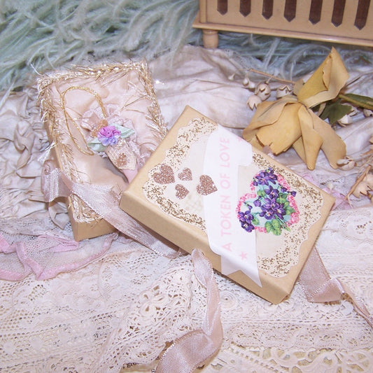 Original design mixed media TOKEN OF LOVE - a porcelain hand extended in friendship.  In a personalized gift box, the ornament is dressed in pastel colors.  