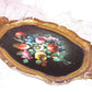Italian-made, handpainted (in oils) wood tole tray. Gold with painted florals on a black background. Length of the tray is 14" x 9" wide. Lightweight piece. 