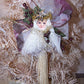 Angel ornament of tulle, gauze, ribbon, twigs and tassel in colors of cream, gold & burgundy. Backed with a wood oval which can be personalized by the new owner