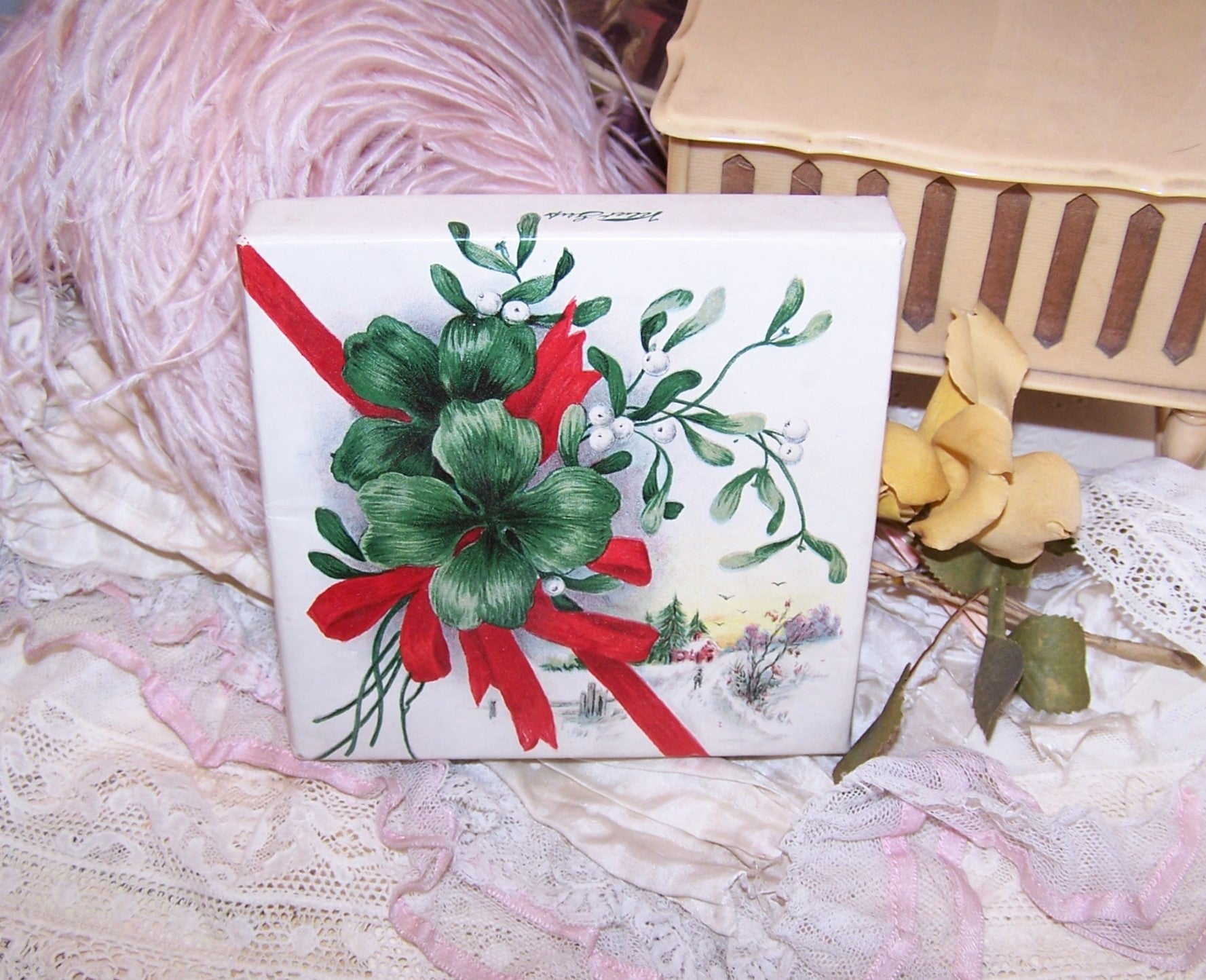 From the Christmas gift giving season, an antique empty ink pad box from Carter of Boston. The paper lid depicts a bundle of mistletoe and four leaf clovers.
