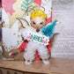 Decorative angel figurine with 'NOEL' sign on a textured surface