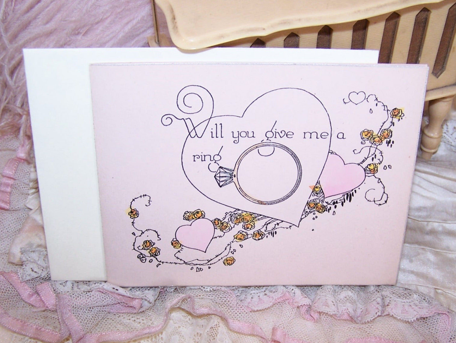 Art Deco greeting card entitled "Will You Give Me a Ring".  Unused condition with original envelope.  Coloring is pink, gold and black. 