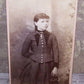 Taken during the late 1890s or so, here's an Antique&nbsp;Victorian cabinet card depicting the portrait of a young girl. She stands with one arm holding a cloth purse and the other tucked behind her back. She wears 2 pieces of gold filled jewelry - a bar pin and a necklace.&nbsp; Size is 2-1/2" x 4-1/8" approx.&nbsp; Condition is very nice with maybe just a tiny mark or two (and some dust speckles).