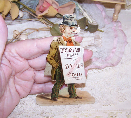Dating to the late 1890s or so, here's a pristine Antique Victorian die cut - a man carrying a sandwich board advertising a play at the Drury Lane Theatre, London England.  Size of the piece is 4-3/4" x 3" approx.  Again, pristine - no paper loss, breaks, discoloration, etc.
