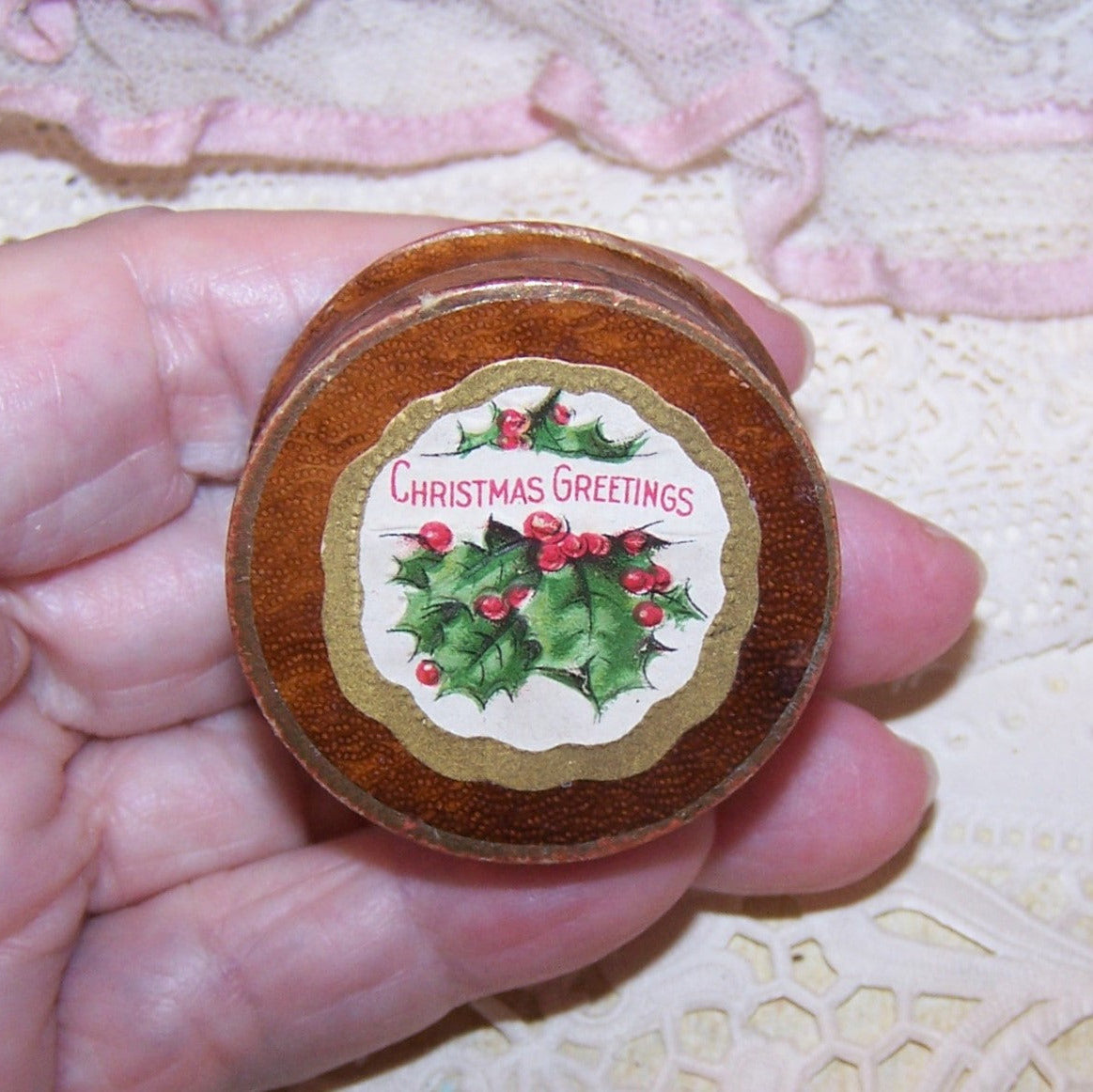 Paper jewelry box with Christmas tag of holly and a sentiment of CHRISTMAS GREETINGS.  Pink cotton on the inside. Size is 1-1/2" wide x 11/16" high. OOAK!