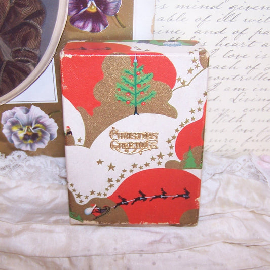 Art Deco Christmas box in red, green and gold. Graphics are Santa's sleigh / reindeer and a Dresden paper message - Christmas Greetings. 4" x 3" x 1-1/2" deep. 