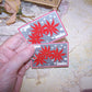 2 Art Deco unused Christmas Gift package tie ons - To and From tags.  Image of a Red Poinsettia. Unused condition - vintage patina to the paper. Unknown maker. 