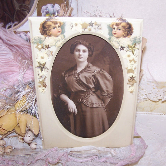 Rectangular celluloid wall frame with graphics of angels & stars.  Easy change of photo to your own image.  No glass.  6-3/8 x 4-1/4. Image size is 5" x 3". 