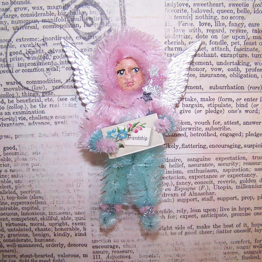 OOAK Chenille Angel carrying an Antique Victorian FRIENDSHIP placard.  For Christmas or any day, the little girl has a face of handpainted clay.  3.5" x 2.5"
