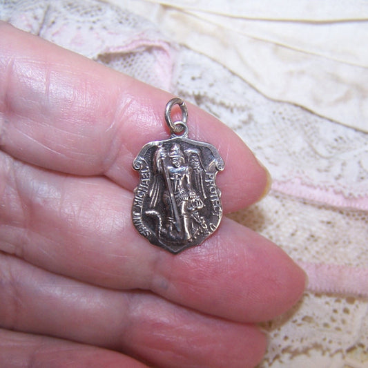 Chapel Sterling Silver religious Saints medal depicting St Michael slaying the dragon. Size is 11/16" high (without bale and ring) x 9/16" wide. 2.5 grams. 