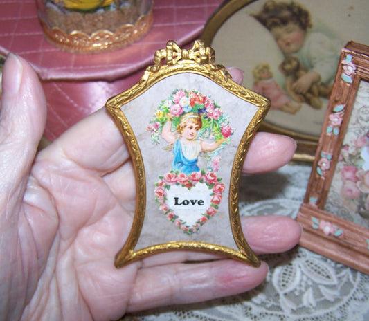 C.1900 French gilt bronze mini frame with an image of a young girl carrying a flower garland; LOVE is written below in a heart shaped design. 3-3/16" x 2-1/4" 