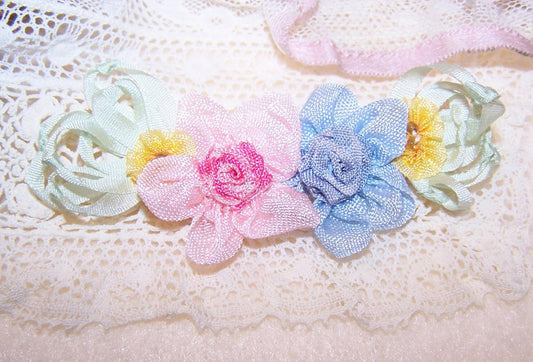 Handsewn ribbon spray in a French Revival manner.  Vintage silk ribbon, rayon and French ombre ribbon make up this 4 floral spray.  3-1/8"x 1-1/4". 