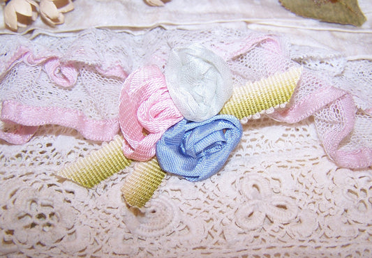 A trio of pink, ice blue and French blue silk florals rest on a background of lime green ombre cotton ribbon.  Size is 2-3/8" x 1-1/8". Entirely handsewn.
