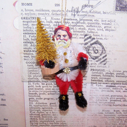 Handcrafted chenille ornament of Santa Claus.  In a retro inspired design, Santa carries a gold glitter Christmas tree.  Gold Cord for hanging from a tree. 