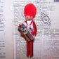 Vintage hand painted wooden ornament - red, white and blue soldier carrying a gift package adorned with an Antique Victorian die cut of a dog's head.  