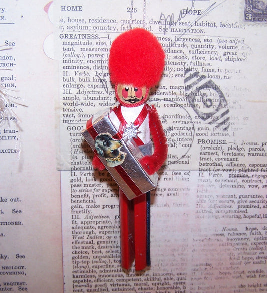 Vintage hand painted wooden ornament - red, white and blue soldier carrying a gift package adorned with an Antique Victorian die cut of a dog's head.  