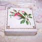 2-3/8" square Jaccards, St Louis jewelry box of cream paper, silk and velvet.  Simply "pin" your gift to the velvet pad. Pink roses die cut top.