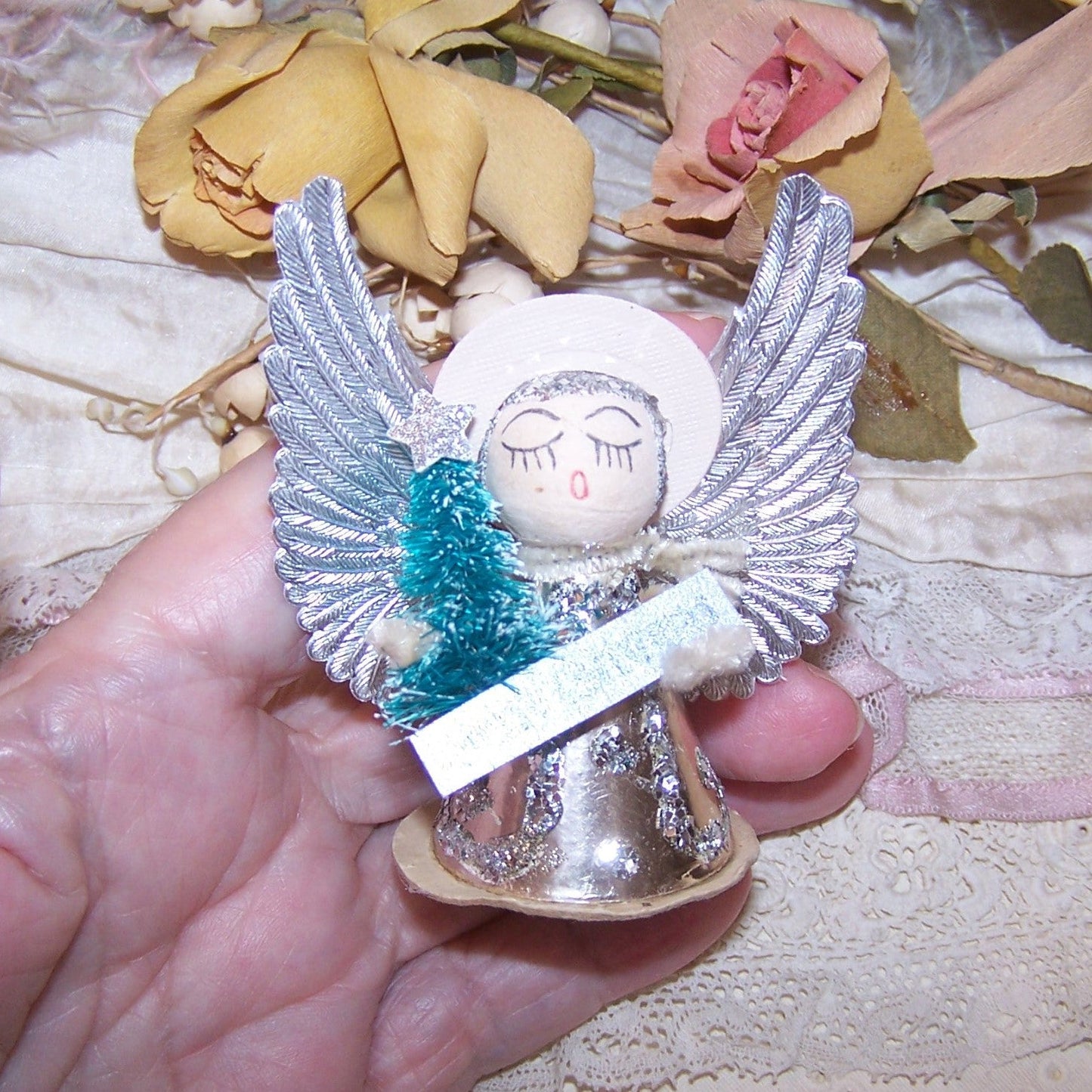Upcycled 1960s Made in Japan foil, Dresden paper and glitter angel ornament.  Pale pink and silver coloring.  Stands 2-3/4" high; width is 2-1/4". 