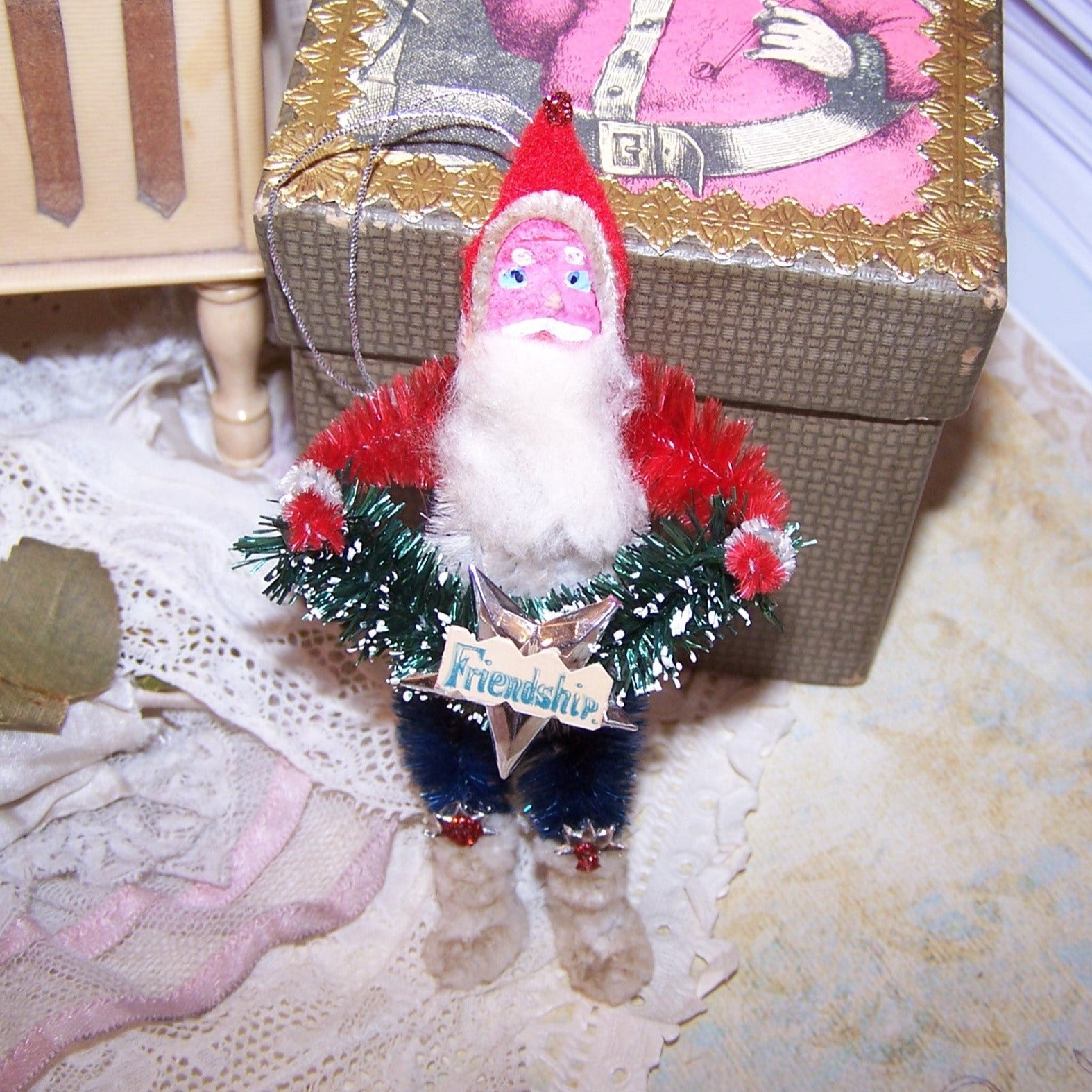 Red, White & Blue chenille Christmas ornament of Santa Claus.  Retro inspired, Santa is very patriotic & carries a bottlebrush garland; sentiment is Friendship!