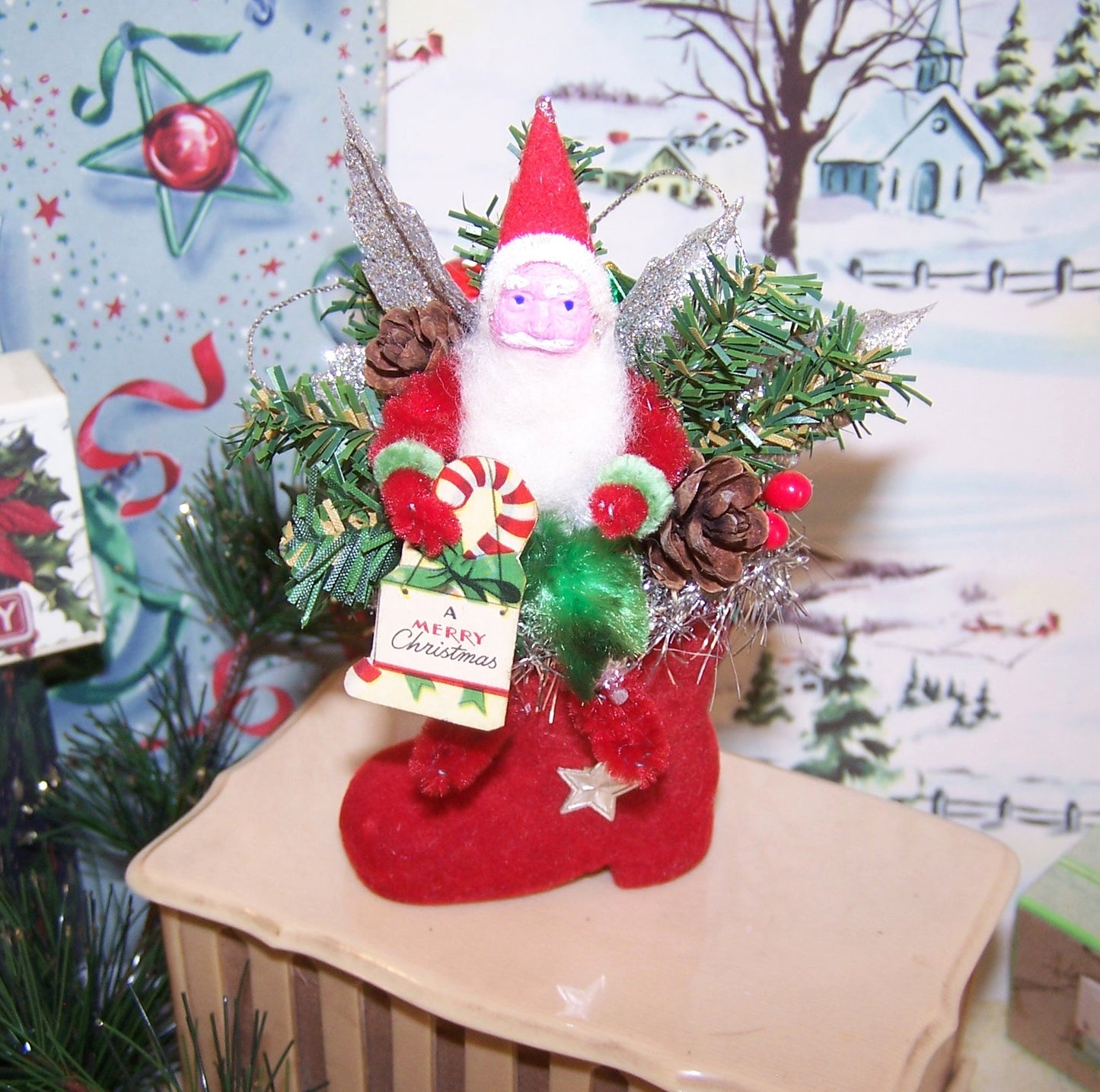Handcrafted Chenille & Japan Clay Face Santa Claus sitting on a flocked boot ornament/mantel decoration. He holds A Merry Christmas sign. 4-3/4" x 3-1/2"