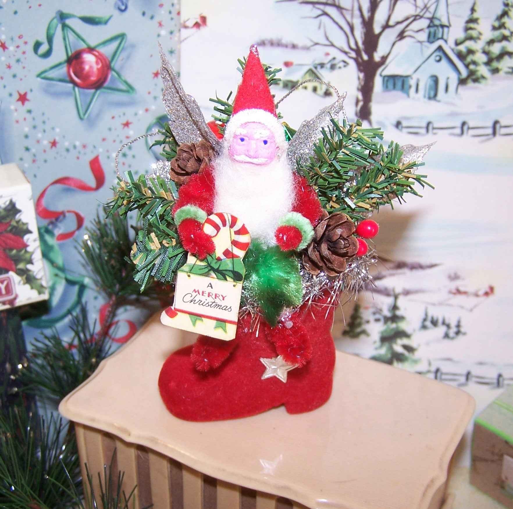 Handcrafted Chenille & Japan Clay Face Santa Claus sitting on a flocked boot ornament/mantel decoration. He holds A Merry Christmas sign. 4-3/4" x 3-1/2"